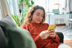 Image Woman relaxed on a couch using the Cara Care app.
