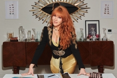 Image Charlotte Tilbury standing over a desk.