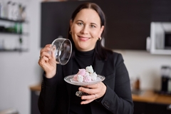 Image a woman holding a glass container with meringue.