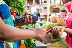Person buying healthy foods at a market in Africa.