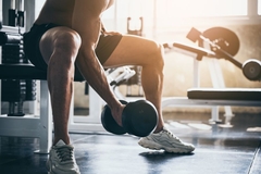 Person working out in a gym lifting weights.