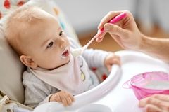Baby being fed yogurt