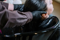 Image Hair salon worker applying hair treatment to a client