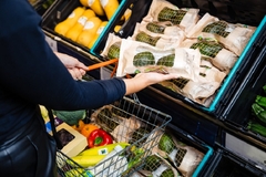 Image a hand picking up avocados in the supermarket