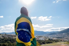 Person with long hair draped in Brazilian flag