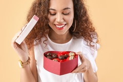 Image Woman opening chocolate box in heart shape.