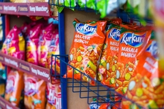 Image Kurkure snacks in a supermarket aisle.