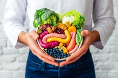 Image man holds a bowl of fibrous veggies, nuts and fruits over his belly