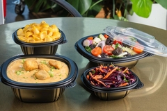Image four black plastic bowls with foods inside