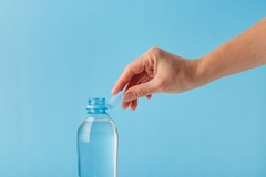 Image hand reaching for plastic bottle lid