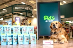 a dog sitting next to packets of dog food