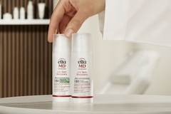 Image hand reaching for white bottled sunscreen