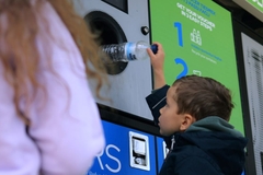 Child deposits beverage bottle