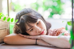 woman reclining on arm with green leaves