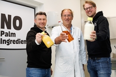 Image three men holding palm oil substitutes in glass bottles