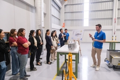 A group of people standing in a line in a factory.
