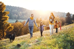 couple with children and dog walking on hill