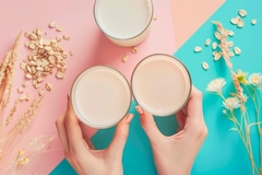 Image hands holding two glasses of plant based milk