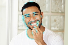 Image A man brushing his teeth with blue neon lines drawn around his face.
