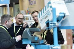 Image Visitors at Packaging Innovations 2025 looking at machine.