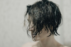 Person with dark wet damaged hair