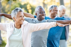 Image Healthy seniors doing yoga outside.
