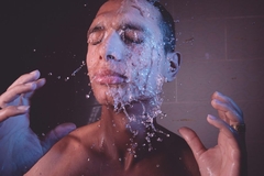 Man in shower washing face and hair