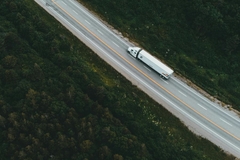 Truck driving across green countryside