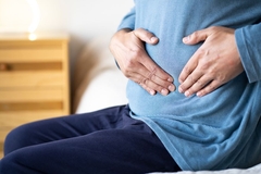 Image Man holding hands on his stomach that hurts.