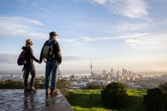 couple standing on mount eden looking at auckland city sky line