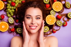 Image woman with clear skin surrounded with fruits