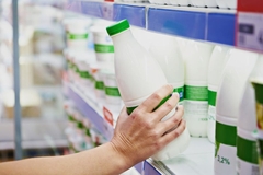 Image A hand holding a bottle of milk