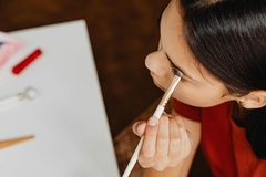 A woman putting on eyeshadow.