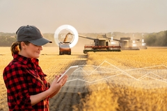 Image female farmer in the field with a tractor in the background
