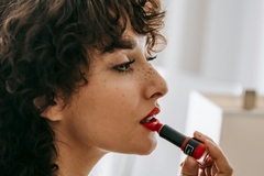 A woman applying lipstick.