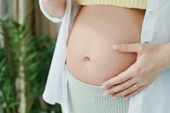 Image pregnant woman's belly with her hand on it