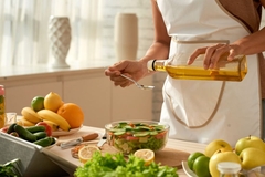 Image pouring oil over salad