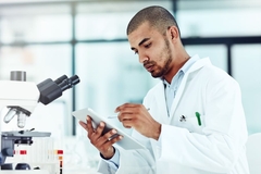 Image Researcher looking on a tablet in a labaratory