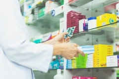 Image A hand holding a pack of pills