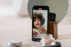 Image Person recording TikTok video applying makeup
