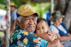 polynesian grandpa and gransdon hug