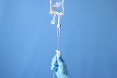 A hand holding a iv drip.