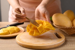 Image using fork to pick mango piece