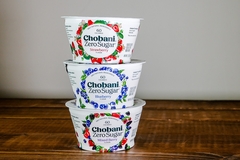 Chobani yogurts on wooden table with white background