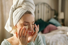 Image Woman applying skin care happily