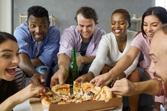 Multiethnic young people gathered around lunch table take pieces of delicious Italian cheese pizza