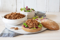 Image vegan pulled meat dish in a white bowl with bread