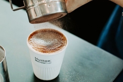 Image A person making a coffee in a cup