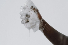 A hand with a sudsy sponge.