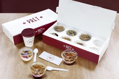 A box of granola pots and spoons